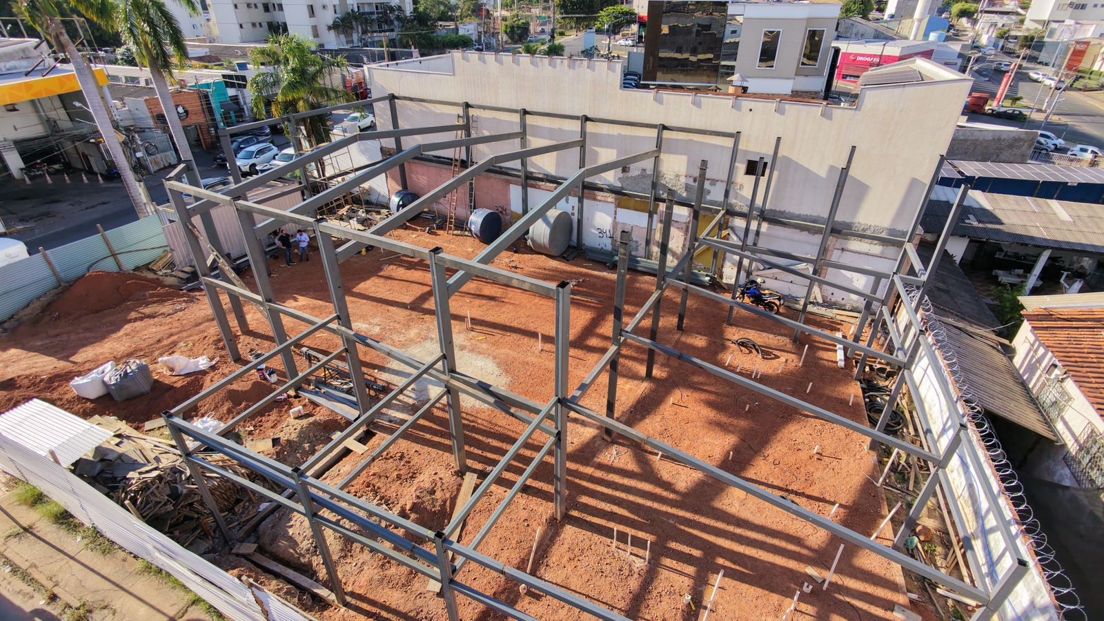 Vista aérea de estrutura metálica em montagem para edificação comercial, com pilares e vigas de aço